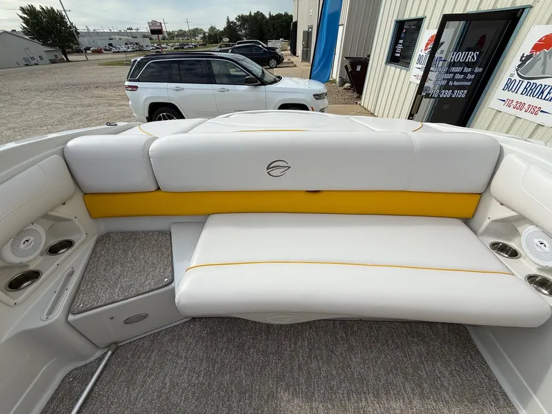Slide: The Image of 2012 Crownline 225 SS boat interior with white and yellow seating, cup holders, and speakers. - 20