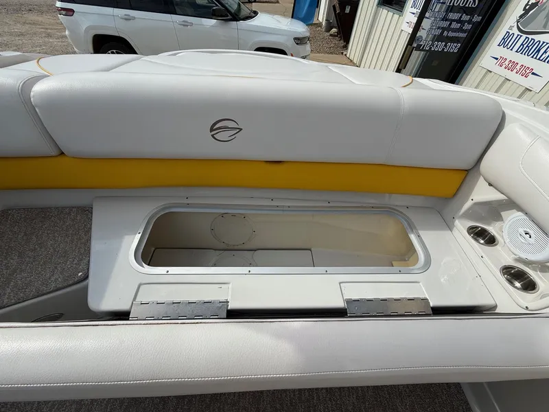 Slide: The Image of 2012 Crownline 225 SS boat interior with storage compartment and cup holders. - 21