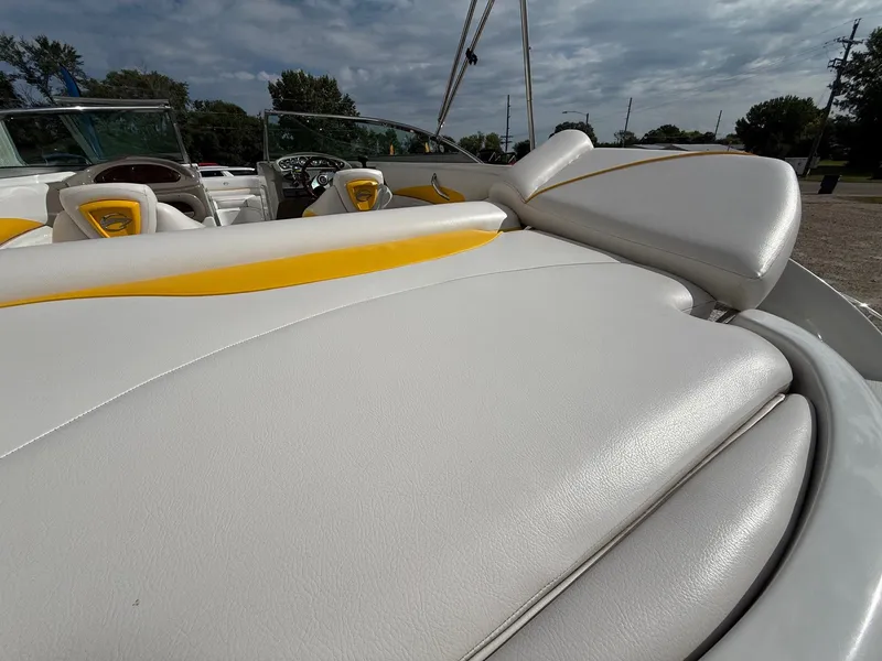 Slide: The Image of 2012 Crownline 225 SS boat interior with white and yellow upholstery under cloudy sky. - 22