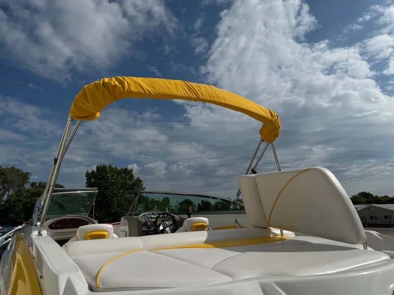 Slide: The Image of 2012 Crownline 225 SS boat with yellow canopy under a partly cloudy sky. - 24