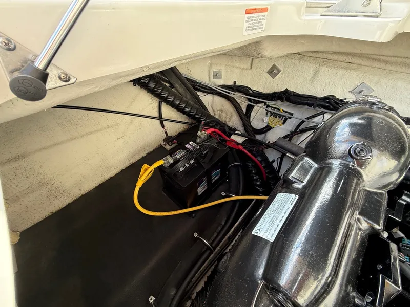 Slide: The Image of Engine compartment of a 2012 Crownline 225 SS boat, showing battery and wiring. - 26