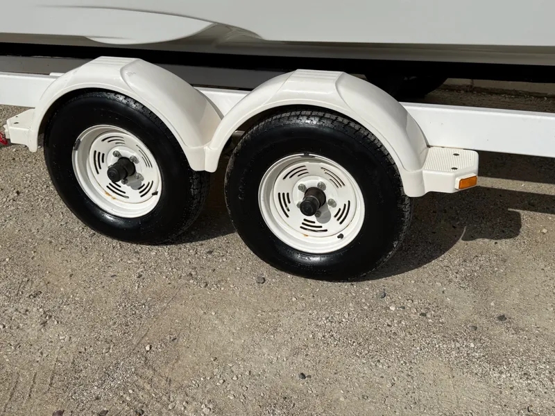 Slide: The Image of Trailer wheels of a 2012 Crownline 225 SS boat on gravel surface. - 27