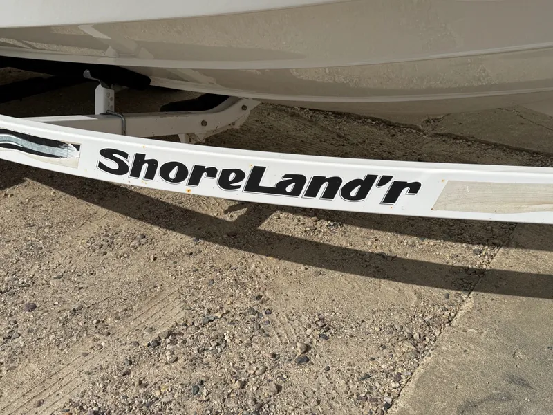 Slide: The Image of ShoreLand'r trailer for 2012 Crownline 225 SS boat on gravel surface. - 28