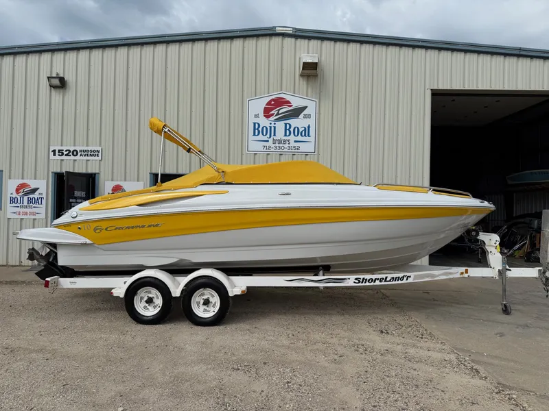 Slide: The Image of 2012 Crownline 225 SS boat with yellow cover on trailer outside Boji Boat Brokers. - 29