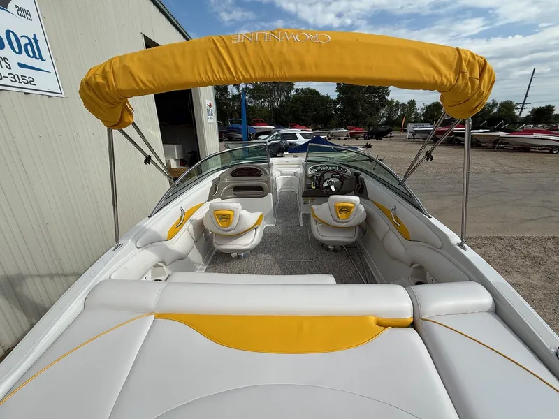 Slide: The Image of 2012 Crownline 225 SS boat with yellow canopy and white interior, parked outdoors. - 8