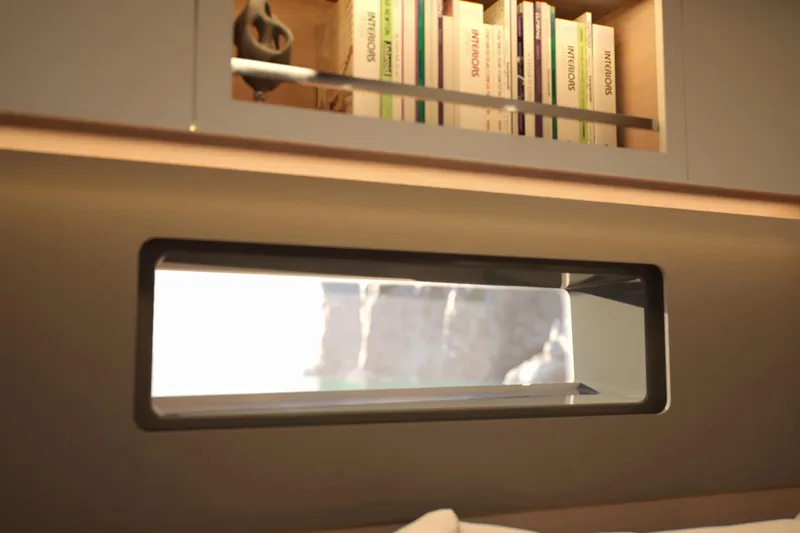 Slide: The Image of Interior view of 2026 Dufour 54 yacht with bookshelf and window. - 10