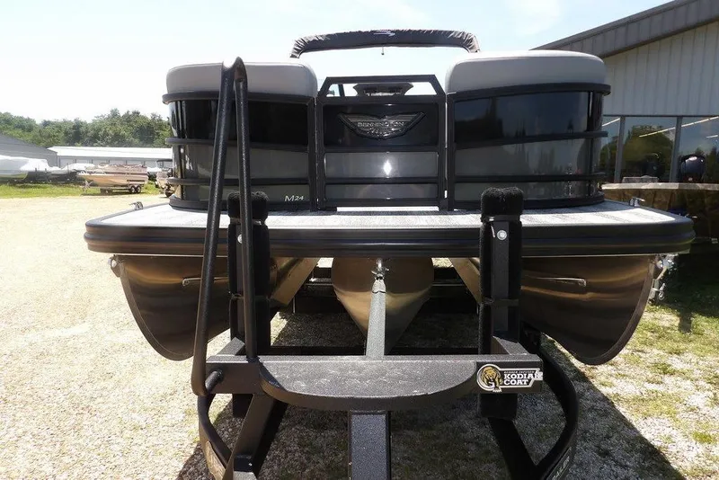 Slide: The Image of 2025 Bennington M Swingback 24 MSB pontoon boat on trailer, outdoor setting. - 11