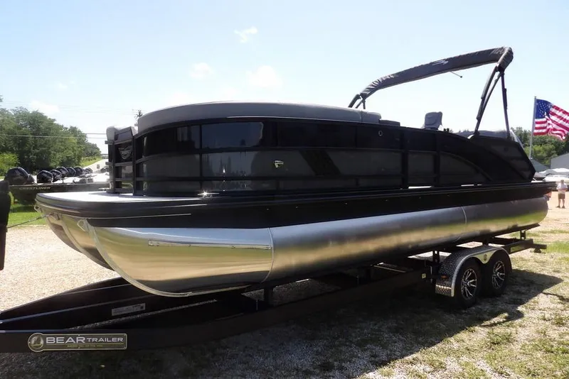 Slide: The Image of 2025 Bennington M Swingback 24 MSB pontoon boat on trailer, displayed outdoors. - 12