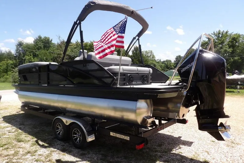 Slide: The Image of 2025 Bennington M Swingback 24 MSB pontoon boat with American flag and Mercury engine. - 13
