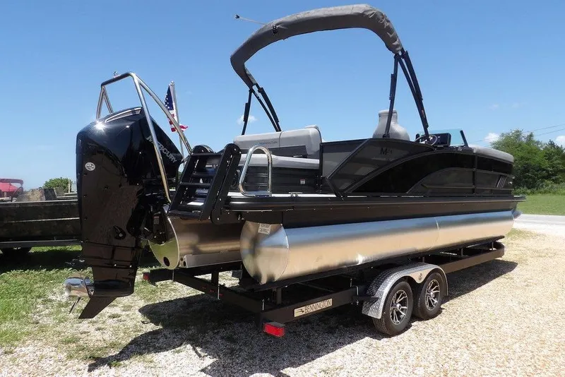 Slide: The Image of 2025 Bennington M Swingback 24 MSB pontoon boat on trailer, sunny day. - 16