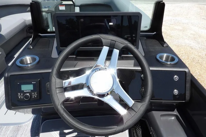 Slide: The Image of 2025 Bennington M Swingback 24 MSB boat dashboard with steering wheel and controls. - 33