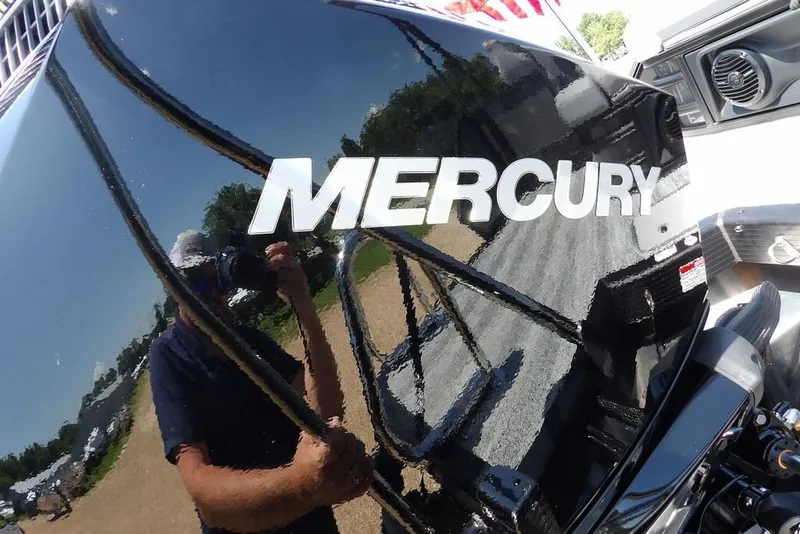 Slide: The Image of Mercury engine on 2025 Bennington M Swingback 24 MSB boat, reflecting surroundings. - 49