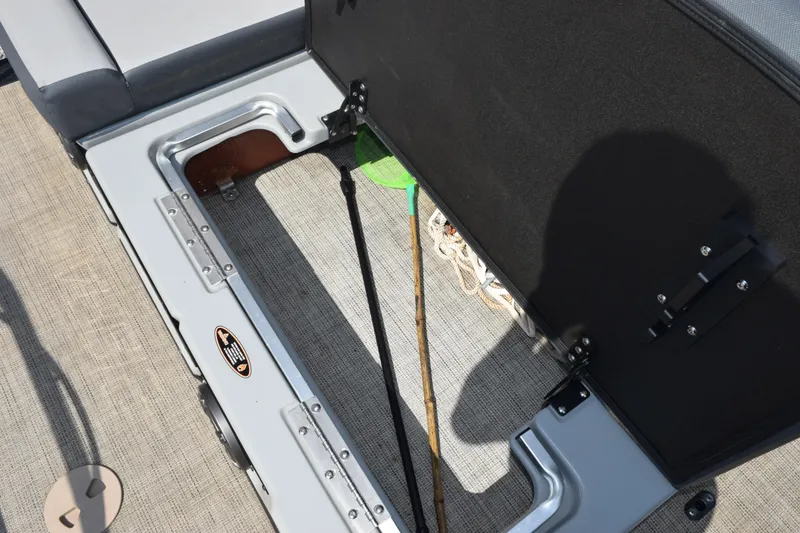 Slide: The Image of Open storage compartment on 2020 Harris Solstice 230 boat, revealing fishing gear and accessories. - 24