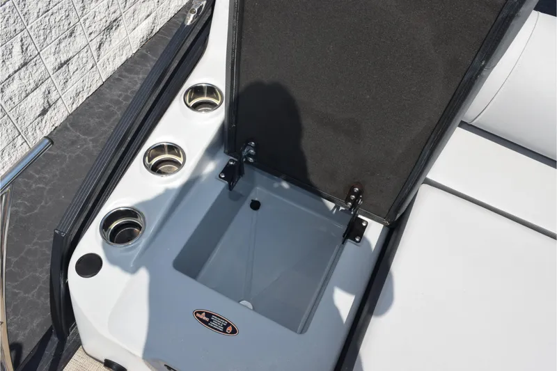 Slide: The Image of 2020 Harris Solstice 230 boat storage compartment with cup holders and open lid. - 25