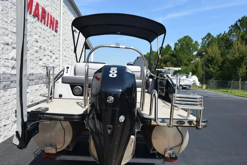 Slide: The Image of 2020 Harris Solstice 230 pontoon boat with outboard motor, parked at a marine dealership. - 5