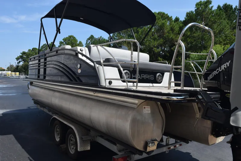 Slide: The Image of 2020 Harris Solstice 230 pontoon boat on trailer, featuring canopy and Mercury engine. - 6