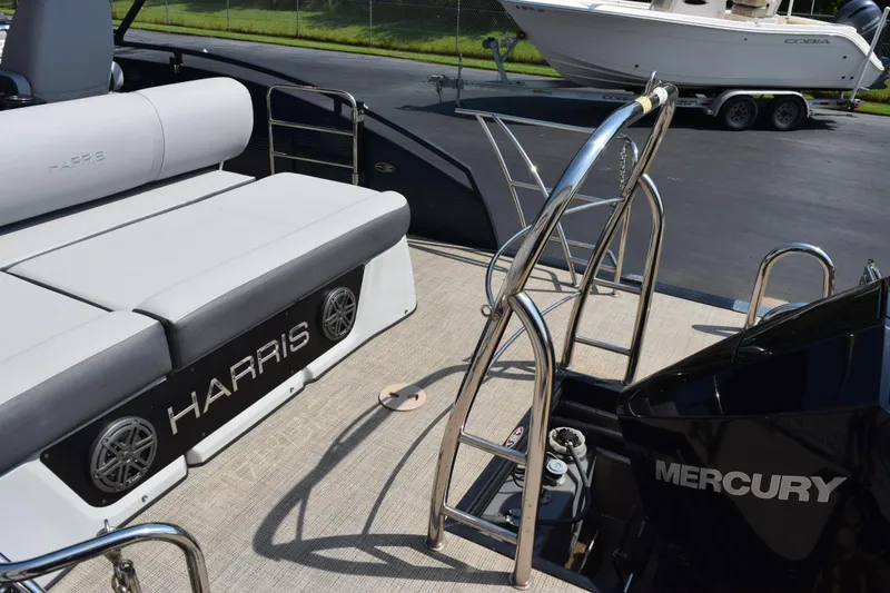 Slide: The Image of 2020 Harris Solstice 230 boat interior with Mercury engine and seating area. - 9