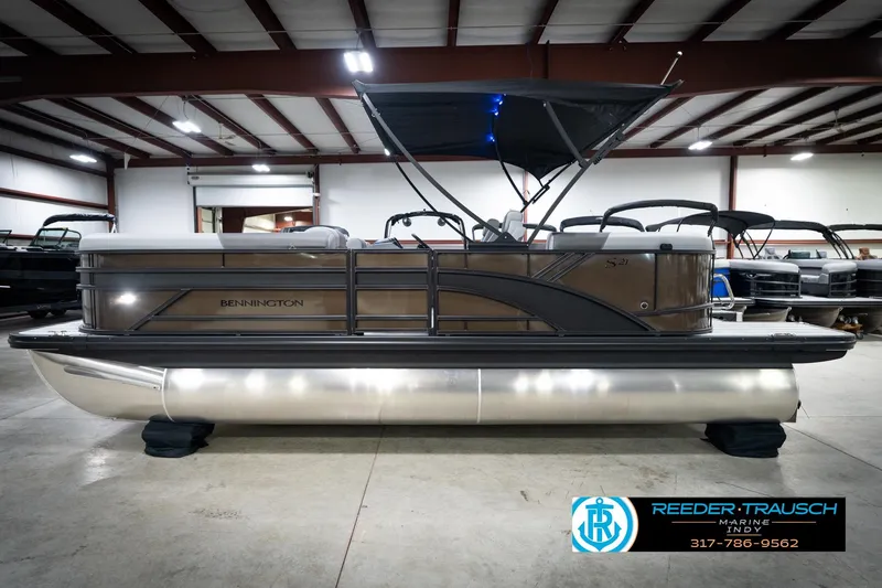 Slide: The Image of 2026 Bennington 21 SSR pontoon boat in showroom, featuring sleek design and canopy. - 11
