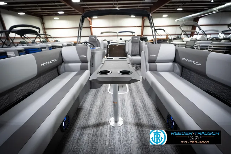 Slide: The Image of 2026 Bennington 21 SSR pontoon boat interior with gray seating and table in showroom. - 16