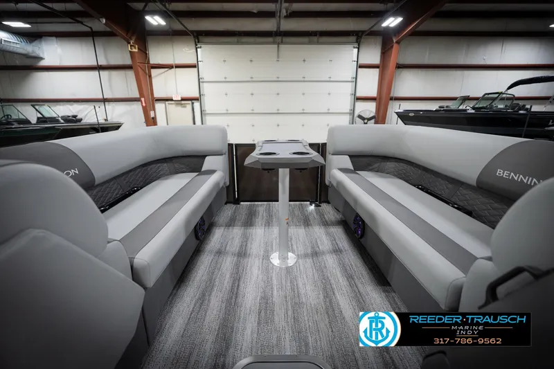 Slide: The Image of 2026 Bennington 21 SSR pontoon boat interior with gray seating and table in showroom. - 21