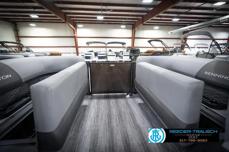 Slide: The Image of 2026 Bennington 21 SSR pontoon boat interior in showroom, featuring sleek seating and modern design. - 29