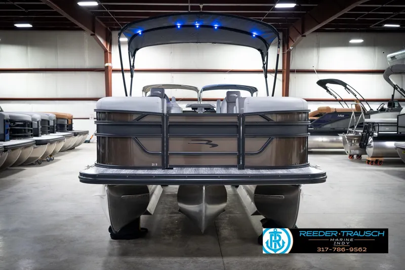Slide: The Image of 2026 Bennington 21 SSR pontoon boat in showroom with canopy and blue lights. - 5
