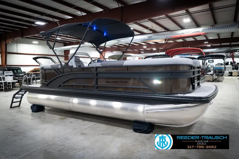 Slide: The Image of 2026 Bennington 21 SSR pontoon boat displayed in a spacious indoor showroom. - 6