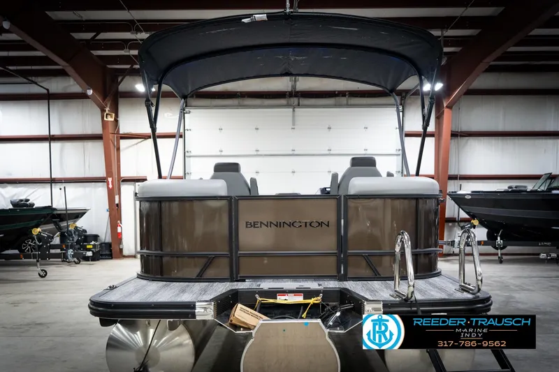 Slide: The Image of 2026 Bennington 21 SSR pontoon boat in a showroom with canopy and seating. - 9