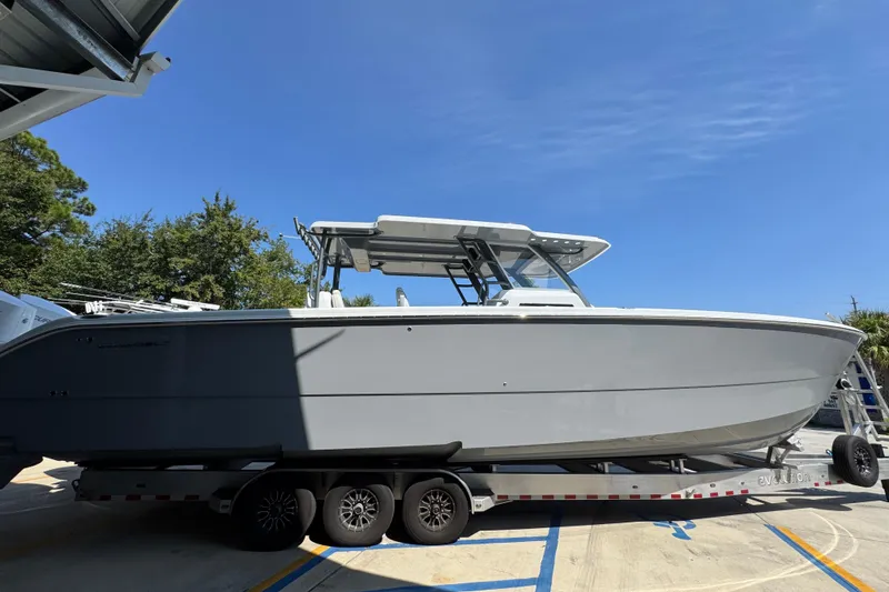 Slide: The Image of 2026 Invincible 40 Catamaran on trailer under clear blue sky. - 11