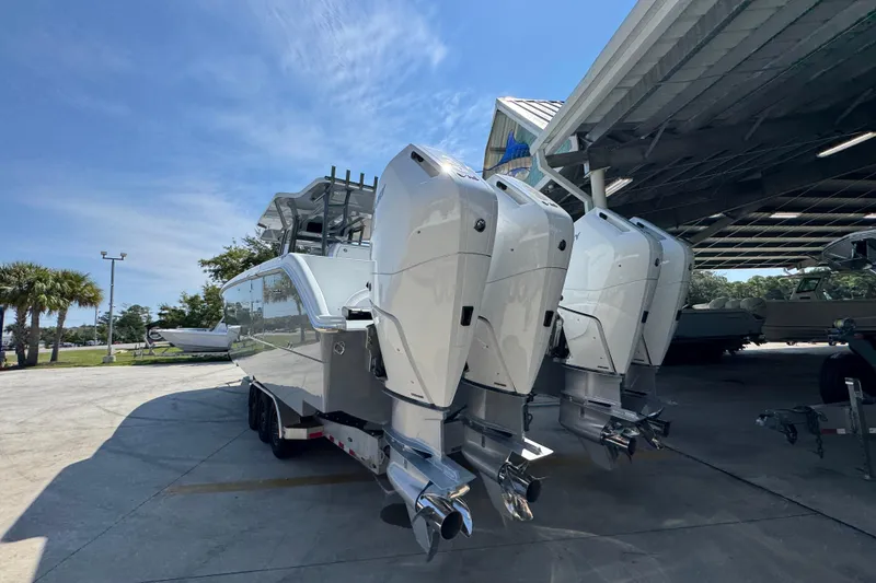 Slide: The Image of 2026 Invincible 40 Catamaran with powerful outboard engines, parked under a canopy. - 15