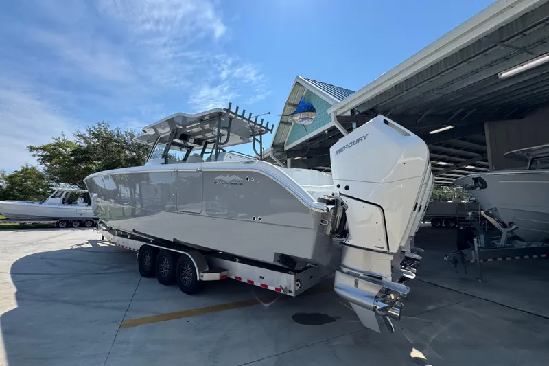 Slide: The Image of 2026 Invincible 40 Catamaran with Mercury engines on a trailer, parked outdoors. - 16