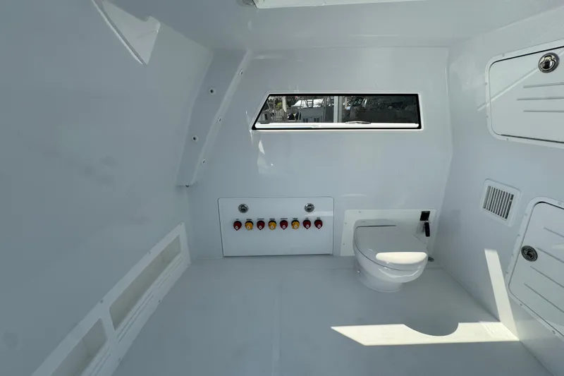 Slide: The Image of Interior of 2026 Invincible 40 Catamaran featuring a compact marine toilet setup. - 24