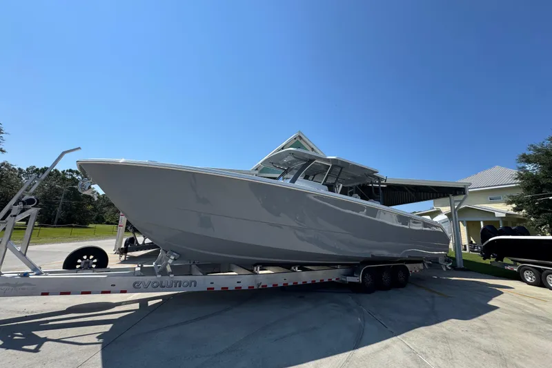 Slide: The Image of 2026 Invincible 40 Catamaran on trailer under clear blue sky. - 3