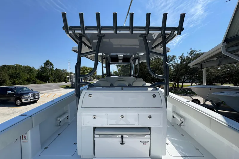 Slide: The Image of 2026 Invincible 40 Catamaran interior with seating and storage, docked under clear sky. - 33