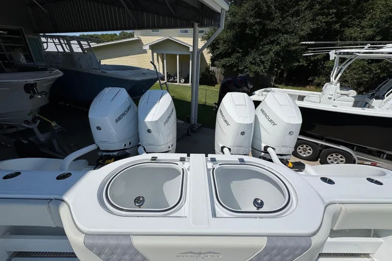 Slide: The Image of 2026 Invincible 40 Catamaran with four Mercury outboard engines in a covered dock. - 37