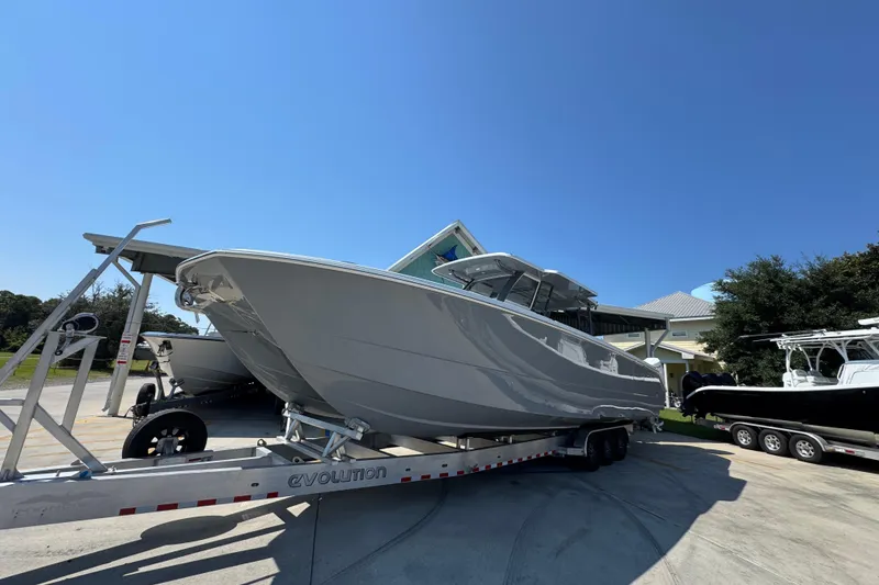 Slide: The Image of 2026 Invincible 40 Catamaran on trailer under clear blue sky. - 4