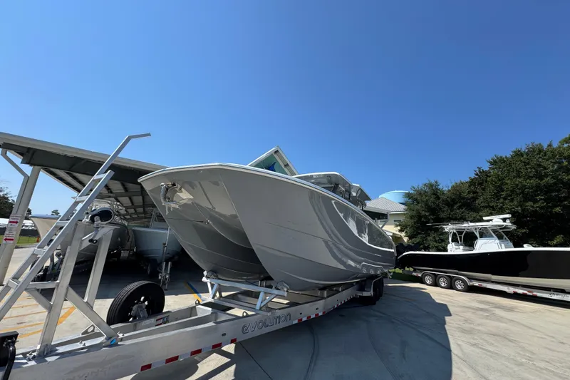 Slide: The Image of 2026 Invincible 40 Catamaran on trailer under clear blue sky. - 5