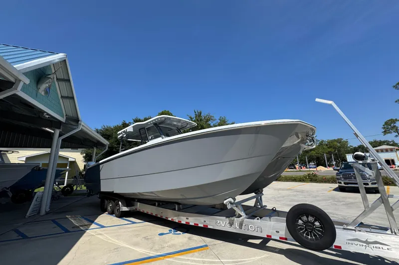 Slide: The Image of 2026 Invincible 40 Catamaran on trailer under blue sky at marina. - 9