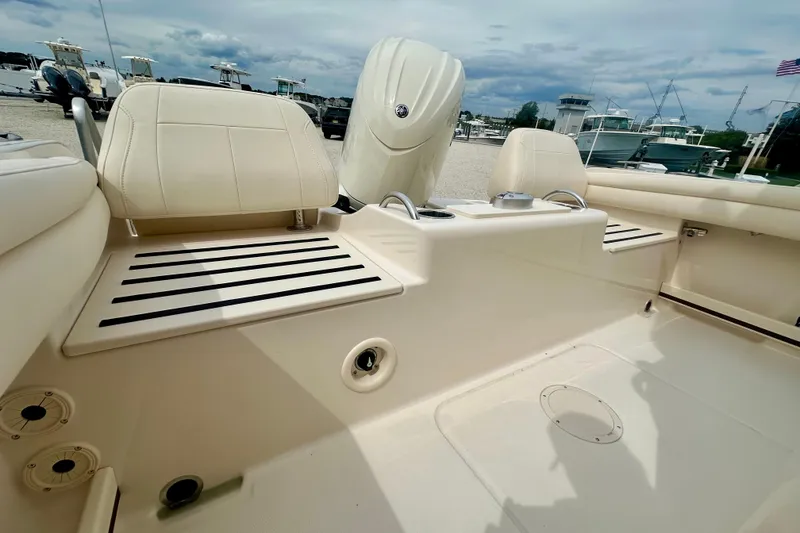 Slide: The Image of 2026 Grady-White Fisherman 216 boat interior with seating and motor, docked under cloudy sky. - 5
