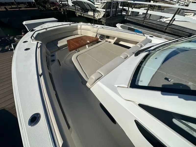 Slide: The Image of 2019 Boston Whaler 350 Realm boat with spacious seating and wooden table. - 13