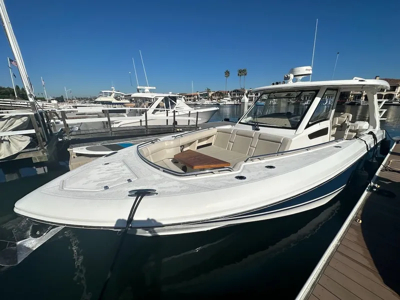 Slide: The Image of 2019 Boston Whaler 350 Realm docked at marina under clear blue sky. - 14