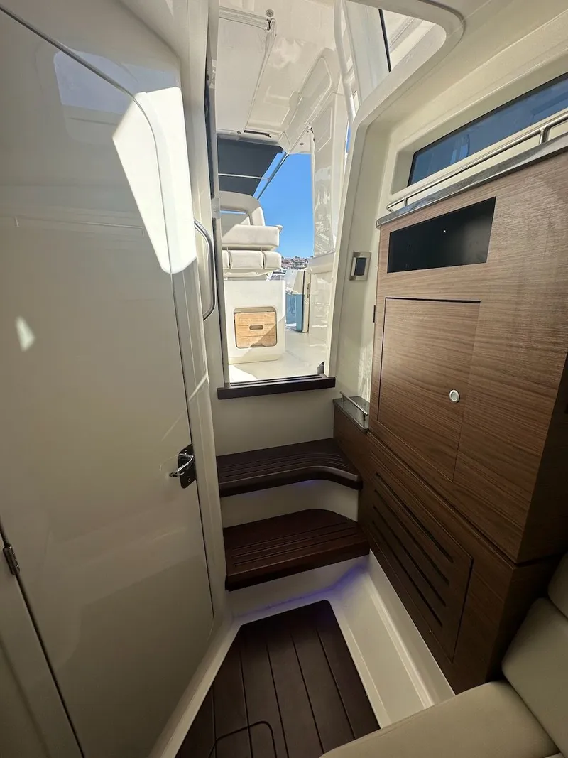 Slide: The Image of Interior view of 2019 Boston Whaler 350 Realm, featuring wooden cabinetry and steps. - 29