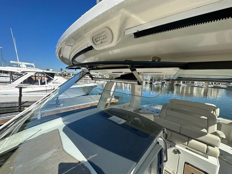 Slide: The Image of 2019 Boston Whaler 350 Realm boat interior with seating and helm, docked at marina. - 39