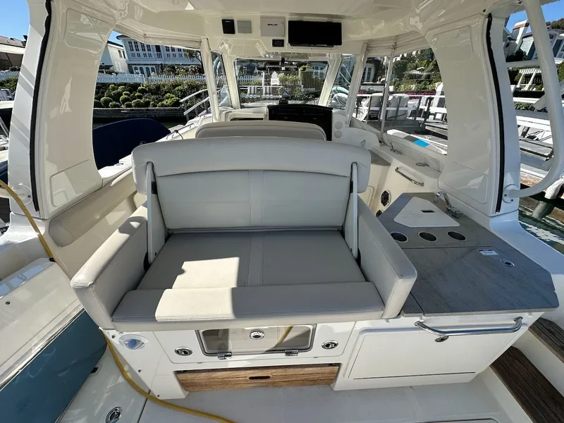 Slide: The Image of 2019 Boston Whaler 350 Realm interior with seating and control panel, docked at marina. - 41
