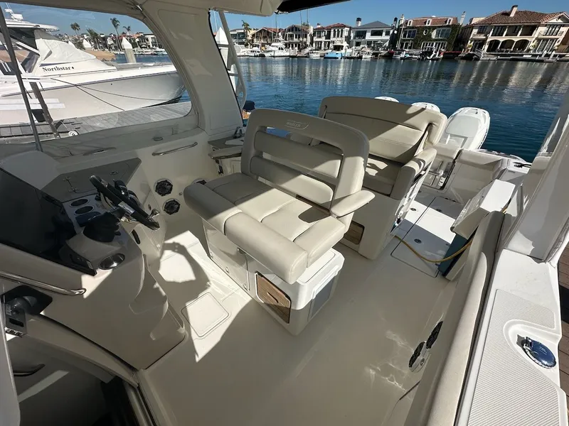 Slide: The Image of 2019 Boston Whaler 350 Realm boat interior with beige seating and waterfront view. - 7