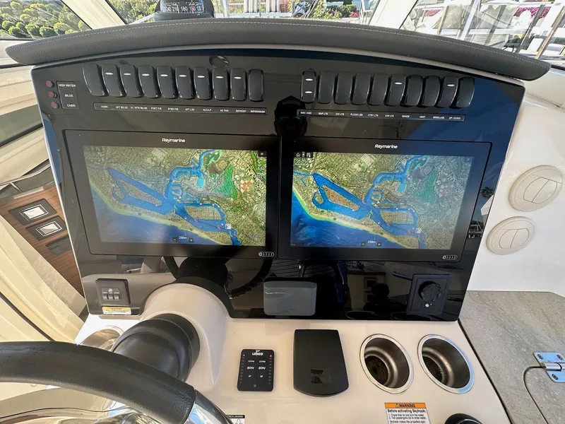 Slide: The Image of 2019 Boston Whaler 350 Realm helm with dual Raymarine navigation screens and control panel. - 8