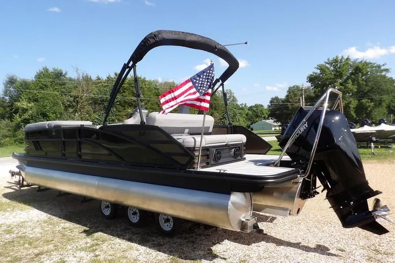 Slide: The Image of 2026 Bennington M Swingback 24 MSB pontoon boat with American flag and Mercury engine. - 5