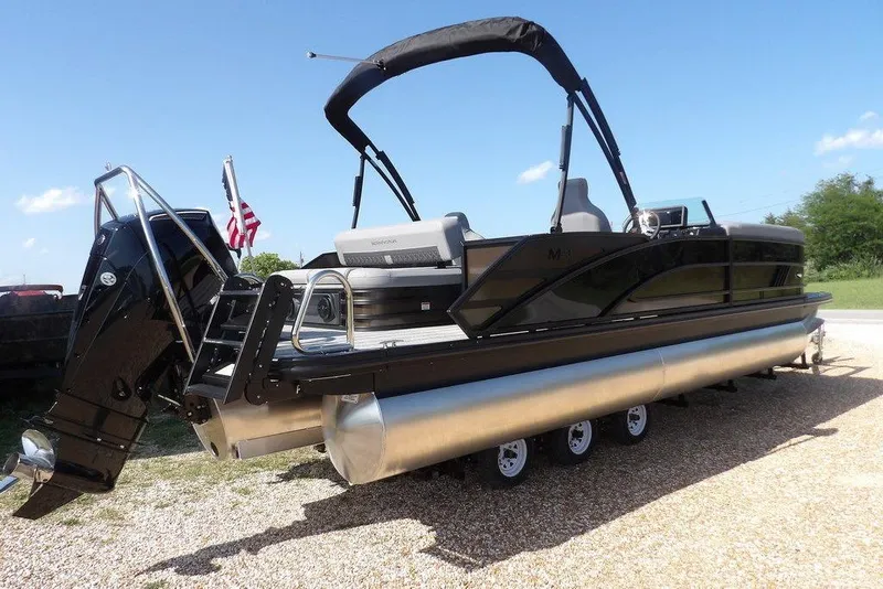 Slide: The Image of 2026 Bennington M Swingback 24 MSB pontoon boat on trailer, sunny day. - 7