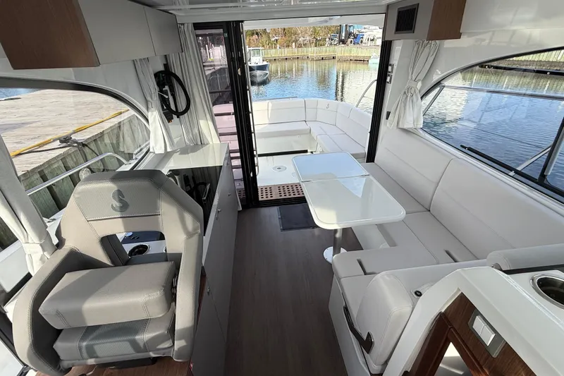 Slide: The Image of Interior of 2026 Beneteau Antares 11 Fly, featuring modern seating and dining area. - 15