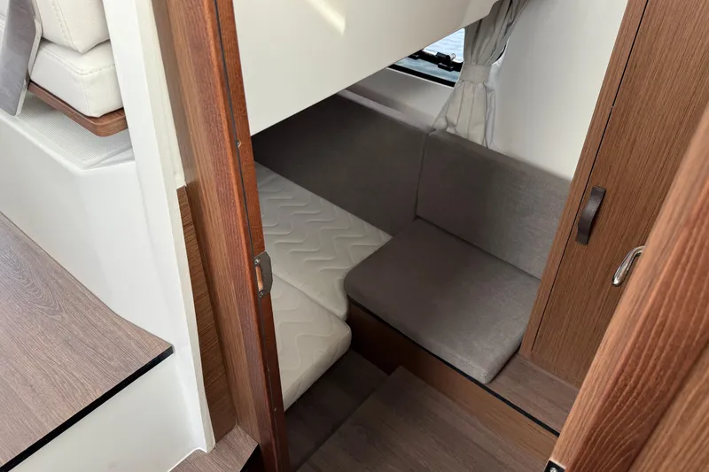 Slide: The Image of 2026 Beneteau Antares 11 Fly cabin interior with cozy seating and wooden finishes. - 17